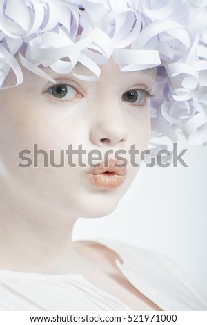 Portrait of a girl with a white smooth skin and curly hair paper.
