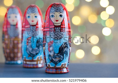 The picture on the doll matryoshka. Rooster - a symbol of the New year. Blurred background