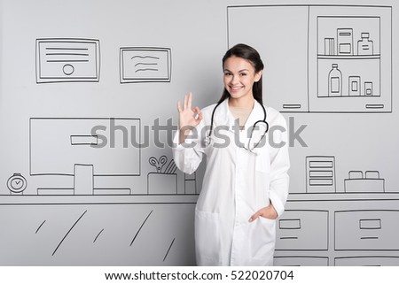 Pretty doctor making an okay gesture