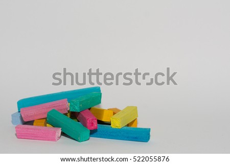 chaotic pyramid of different colored crayons on a white background. Pastels of pink, blue, green. Colorful  chalk. copy space concept for text, word, message. mock up sample