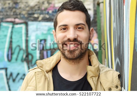 Portrait of young latin man. Urban scene. Royalty-Free Stock Photo #522107722