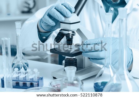 men in a laboratory microscope with microscope slide in hand Royalty-Free Stock Photo #522110878