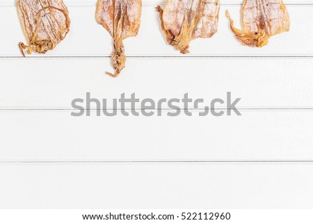 Top view photography of Thai style dried squids on white wood background.