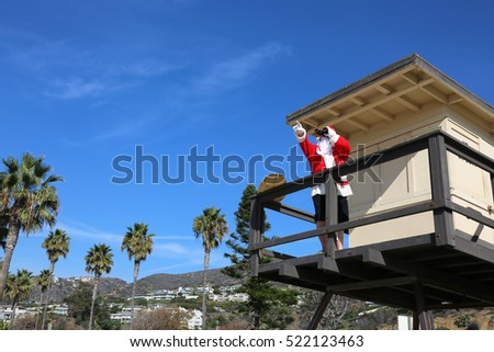 Santa Claus Life Guard. Santa Lifeguard. Santa Claus is a lifeguard at the beach in a lifeguard tower outside. 