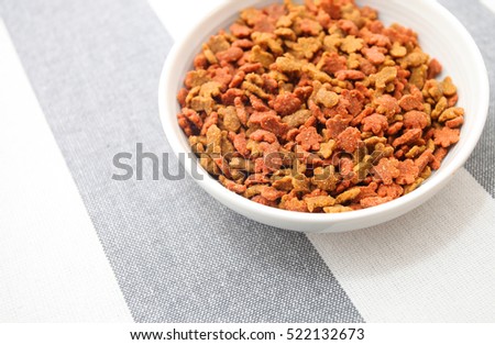 Dry cat foods over modern stripped tablecloth background