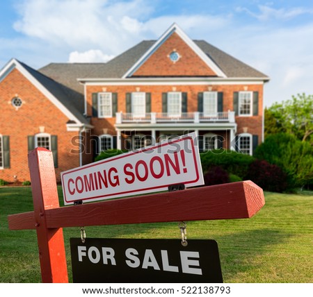 For Sale and Coming Soon realtor sign in front of large brick single family house in expansive grass yard for real estate opportunity