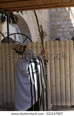 Orthodox Jews performing the commandment of taking of the Four Kinds on Sukkot holiday ( etrog, lulav, myrtle and willow ).