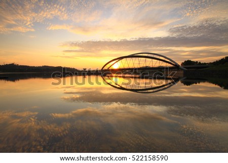 Sunrise at a modern bridge as a background. The beautiful panorama,reflection in the water