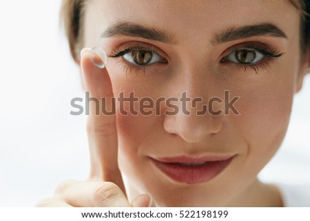 Eye Care And Contact Lenses For Eyes. Closeup Of Beautiful Woman Face With Smooth Skin And Perfect Makeup Applying Eyelens With Finger. Female Model Putting In Contact Eye Lens. Vision And Health Royalty-Free Stock Photo #522198199