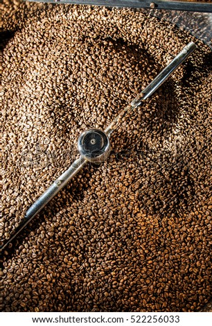 Roasted coffee beans. Industrial coffee machine.