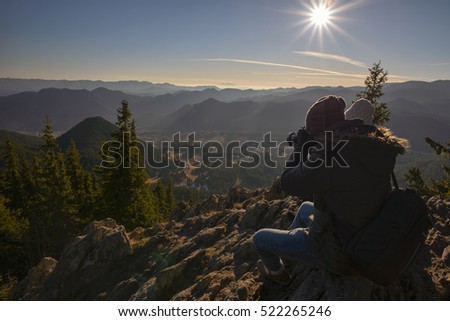 Photographer and girlfriend on top of mountain taking pictures