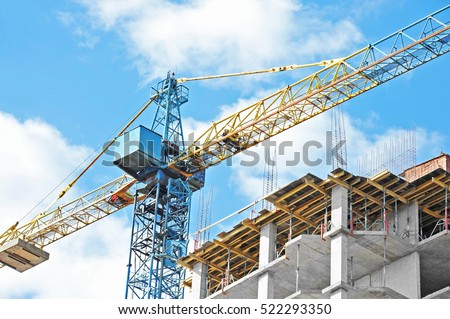 Building crane and building under construction against blue sky Royalty-Free Stock Photo #522293350