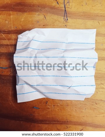 textured paper note over old wood table background