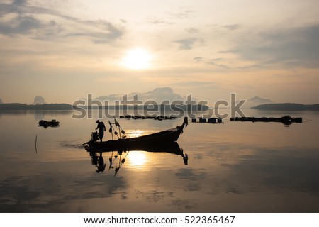 Early morning fishing boat navigation lamps. Fishermen fishing in the early morning golden light. Fisherman boat. Fisherman silhouette. Fisherman net.Photo Fisherman Silhouette,southern Thailand