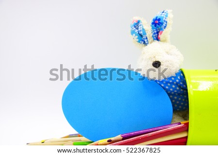 Happy Easter Holiday with Bunny or rabbit in blue with pencil and blank note in blue egg shape on white background