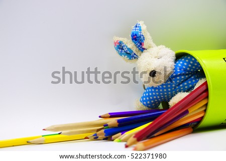 Bunny or rabbit in blue with pencil and blank note in blue egg shape on white background