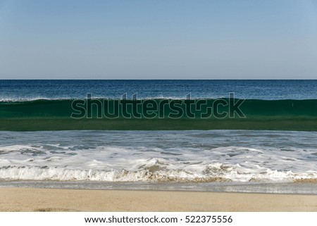wave that breaks on the the beach with foam, background sea and blue sky with, horizontal photo, front view