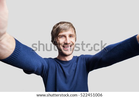 Handsome man taking selfie picture. Isolated on gray background