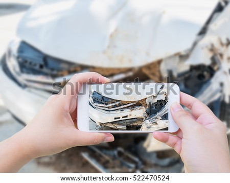 Female using mobile smart phone taking photo of the car crash accident damage for insurance