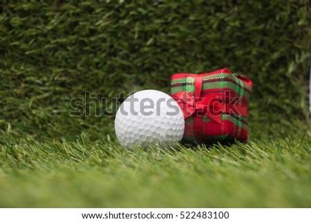 Golf ball with Christmas ornament on green grass background