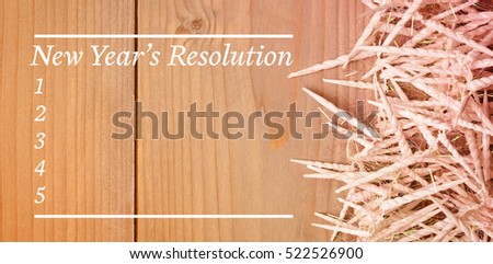 Composite image of new years resolution list against wooden wall