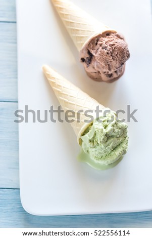 Two cones of nut-flavored ice cream on the white background