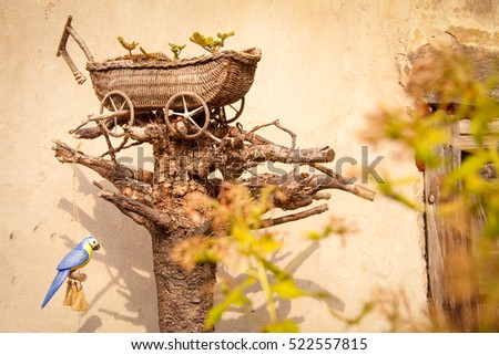 Wooden hand made decoration in the garden close to the house Royalty-Free Stock Photo #522557815