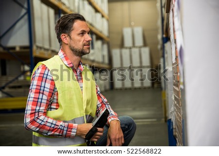 Man in a warehouse is checking inventory levels of goods. First in first out, Last in last out concept photo