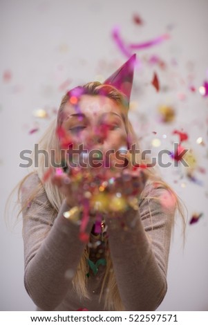 Beautiful  woman blowing confetti in the air party new years eve celebration isolated on white background