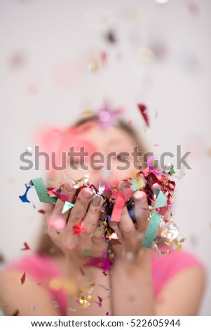 Beautiful  woman blowing confetti in the air party new years eve celebration isolated on white background