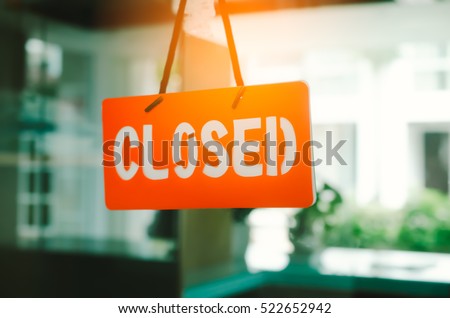 Closed sign hang on mirror door front of office room. Business and service concept. Vintage tone filter color style.