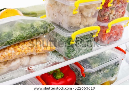 Frozen food in the refrigerator. Vegetables on the freezer shelves. Stocks of meal for the winter. Royalty-Free Stock Photo #522663619