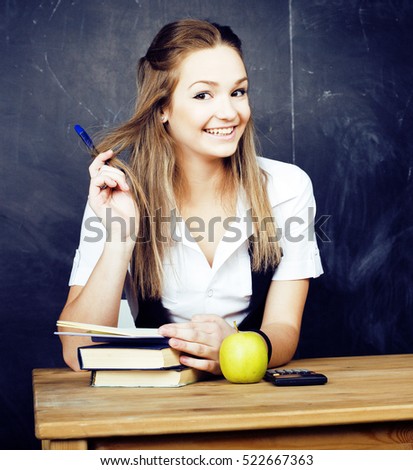 portrait of happy cute student with book in classroom