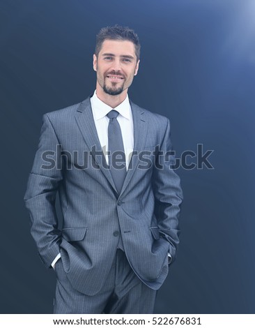 Business man standing near dark wall