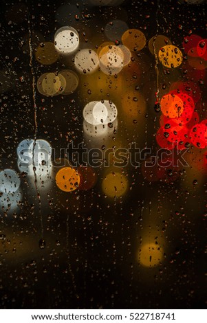 Rain drops on window with street bokeh lights, colorful street lights