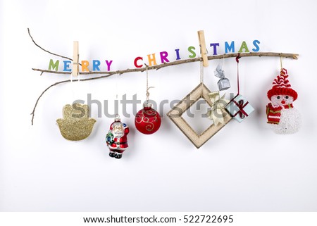 Merry Christmas and Happy Hanukkah- Wooden thin branch with hanging toys, gifts, jewish hamsa and "Merry Xmas" greeting text writen with small colorful letters on white background