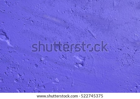 Rough concrete wall painted in vibrant violet color