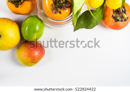 Fresh fruits- lime,brunch of tangerines and persimmons with place for text.Isolated on white background.Vegetarian concept.Mock up for notes, horizontal composition 