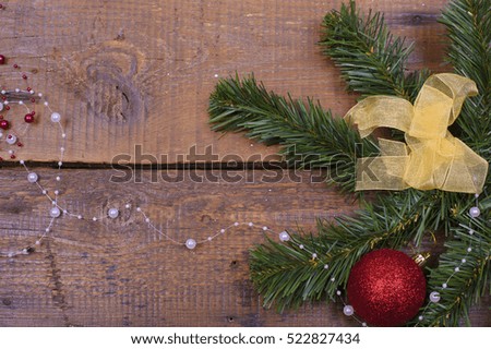 pine branches and Christmas decorations on wooden background