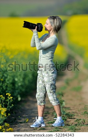 professional woman photographer on field in summer