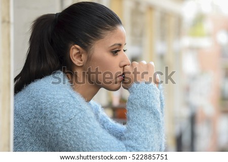 young beautiful sad and desperate hispanic woman suffering depression looking thoughtful and frustrated at apartment balcony looking depressed at the street  Royalty-Free Stock Photo #522885751