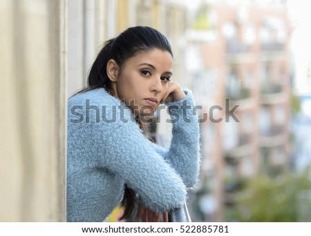 young beautiful sad and desperate hispanic woman suffering depression looking thoughtful and frustrated at apartment balcony looking depressed at the street  Royalty-Free Stock Photo #522885781