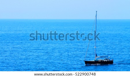 Image of a small boat sailing on the big ocean.