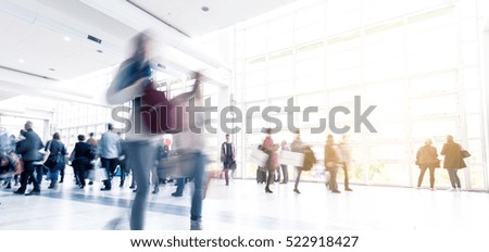 blurred people walking in a modern hall