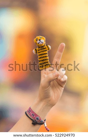 tiger handpuppet in front of blury background