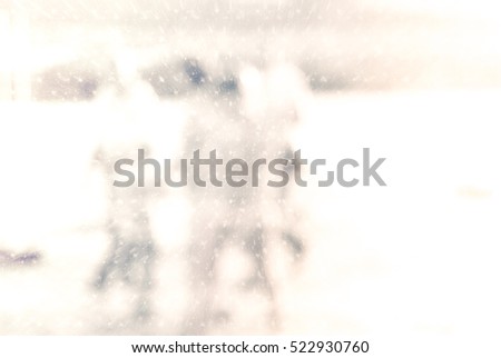Winter city commuters with snow. Blurred image of people walking on the street. back home after work. Defocused figures of people with snowing effect and frost.