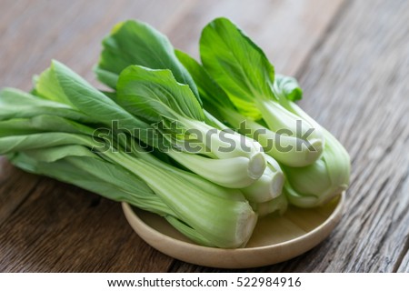 Bok choy (chinese cabbage) on wood table. Royalty-Free Stock Photo #522984916
