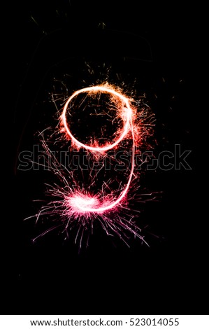 "9" number drawn with bengali sparkles isolated on black background,number from sparkler on black background