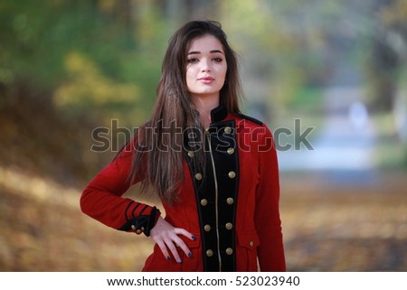 beautiful girl standing and looking at the camera in full length, autumn photo shoot, fall leaves, orange leaf