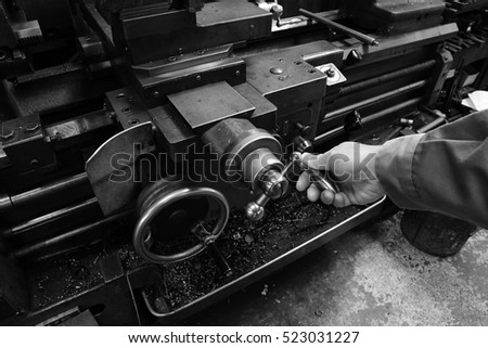 Craftsman using the Obsolete lathe. Black-and-white photo.